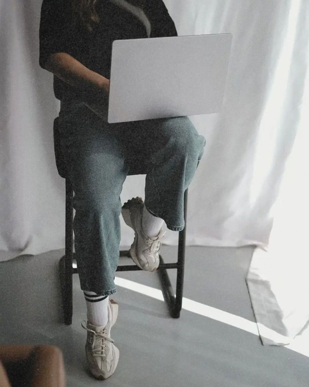 Frau auf Hocker mit Laptop